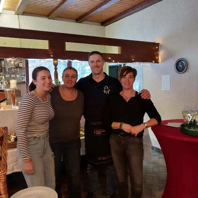Vier Personen in einem Gastraum