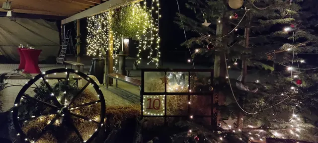 Wagenrad mit Lichterketten und Tannengrün