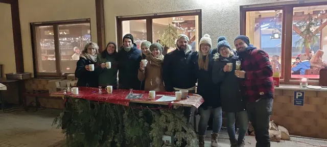 Gruppe mit Getränken an weihnachtlich geschmückten Tischen