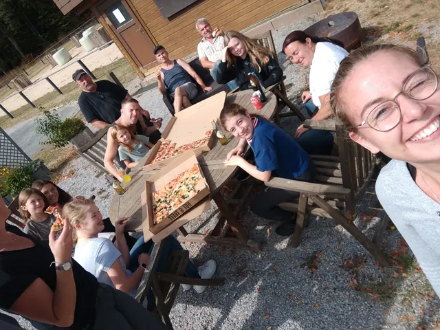 Gruppenselfie an einem Tisch mit Pizza